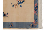 Ivory field and blue border of a Vintage Art Deco runner, with pink florals, butterfly, and fringe.