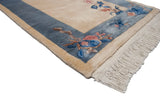 Corner of Art Deco runner, plush ivory pile, intact fringe, and blue floral border.