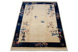 Lower right corner detail of the Art Deco carpet with vased pink and blue floral sprays.