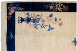 Art Deco vintage rug corner with ivory field, cobalt border, pink and blue vased motifs.