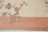 Vintage Art Deco carpet detail: ivory field with pink and blue blossomed branch, pale dusty coral border.