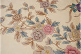 Vintage Art Deco carpet detail: pink roses, lavender blossoms, pale blue leaves on ivory.