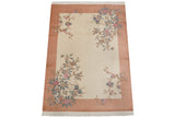 Art Deco carpet corner showing pink, blue floral branches on ivory, with dusty coral border.