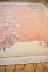 Shallow carved coral, mauve, and blue blossomed roses with ivory fringe on a vintage carpet.