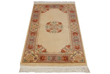 Ivory field Vintage Peking rug with mauve, cinnabar, and seafoam floral motifs.