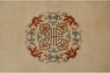 Peking rug detail: Roundel medallion with geometric floral motifs in mauve, cinnabar, seafoam.