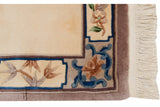 Vintage Peking rug corner: blue scrolling floral motifs, sandalwood border, and cream fringe.