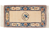 Peking rug's roundel medallion featuring cobalt blue mating birds and a mauve flower.