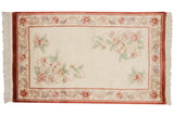 Vintage Peking rug's flowing main border with floral vines and cinnabar red details.
