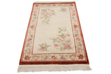 Vintage Peking rug corner with flowing floral vine border in cinnabar red, mauve, and ivory.