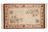 Cinnabar red border, ivory field, pale floral vines, and fringe on a Vintage Peking rug.