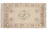 Vintage Peking rug corner features perched lovebirds, floral roundel, and cream fringe.