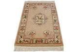Vintage Peking rug corner detail: perched birds, mauve flowers, green leaves, cream fringe.