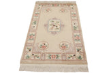 Cream Peking rug corner: original fringe, intact selvage, pink floral roundel.
