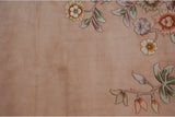 Art Deco floral spray on vintage rug: dusty mauve field, pale green leaves.