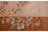 Floral sprays of lotus flowers and leaves in mauve, copper, green on two-toned Art Deco rug.