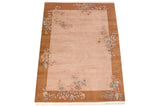 Art Deco vintage rug corner with dusty mauve field and floral vase design.
