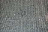 Blue-gray ribbed backing of the vintage rug showing a minor scuff.