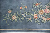 Vintage Art Deco carpet showing denim blue field, terracotta floral details, and subtle tone variation.