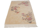 Raised pink and mauve floral sprays on a cream Art Deco rug with intact fringe.