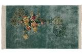 Ivory fringe frames the dense, blossomed floral motif on the aqua Peking rug.