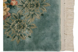 Detail of Japanese Peking rug's thick aqua blue pile, saffron fuchsia florals, and ivory fringe.