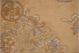 Peking rug corner featuring Chinese emblem, table motifs, and florals in beige and mauve.