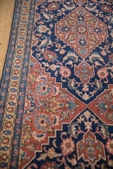 Angled view showing the intricate floral border and original side cord selvage of the vintage Tabriz runner.