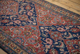 Even hand-knotted pile of a vintage Tabriz runner with navy and brick red floral motifs.