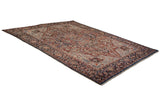 Angled view of a vintage Bakshaish carpet with a sprawling medallion and an abrashed sapphire blue border.