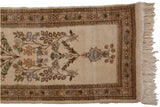 End of a vintage Tabriz runner with blossomed branches, a floral border, and cream fringe.