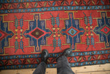 Serrated leaf motifs and stepped geometric medallions on a brick-red antique Northwest Persian runner.