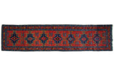 Antique Northwest Persian runner with geometric stepped medallions in indigo blue on a brick red field.