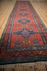 Angled view down the length of an antique Persian runner, highlighting its repeating geometric medallions.