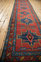 A long view of a collector's antique Persian runner highlights its repeating geometric pattern.