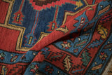 Even wool pile and colorful meandering leaf border on a folded antique Northwest Persian runner.