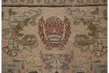 Close-up of the Cyrus Crown trademark detail woven into the beige, hand-knotted pile of the vintage Tabriz carpet.