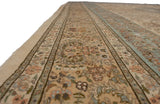 Side perspective of a vintage Tabriz carpet with a plush pile and Rococo-style scrolling floral borders.