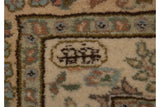 A weaver's insignia hand-knotted into the cream minor border of a vintage Persian Tabriz carpet.