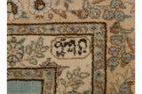 Close-up of the weaver's insignia within the minor floral border of a vintage Tabriz carpet.