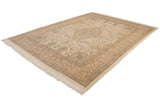 Diagonal view of a vintage Tabriz carpet showing its ivory field, intricate borders, and soft full pile.