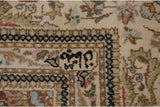 A weaver's insignia hand-knotted into the ivory minor border of a vintage Tabriz carpet.