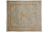 Detail of a perched peacock and blossomed branches on the powder blue field of a vintage Persian rug.