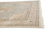 A weaver's signature is visible in the minor floral border of this vintage Tabriz carpet corner.