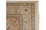 Corner of a vintage Persian Tabriz showing floral borders, weaver's mark, and secured ivory fringe.