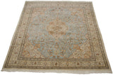 Perspective view of a vintage Tabriz carpet's powder blue field, floral medallion, and ivory borders.