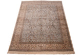 Corner of vintage Tabriz carpet, with fringe and border featuring deer and blossomed patterns.