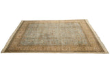 Angled perspective on a vintage Tabriz rug with a sprawling forest scene and detailed beige border.