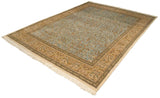 An angled view of the vintage Tabriz carpet highlighting its sprawling forest scene and beige border.