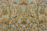 Pictorial detail of peacocks and blossoming trees on the rug's powder blue pile.